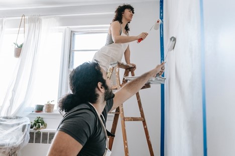 two people painting a home