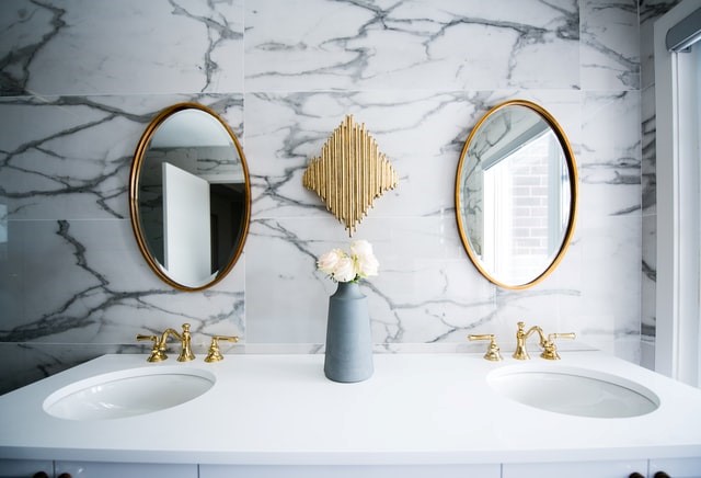 White ceramic sink with mirrors on tiled wall
